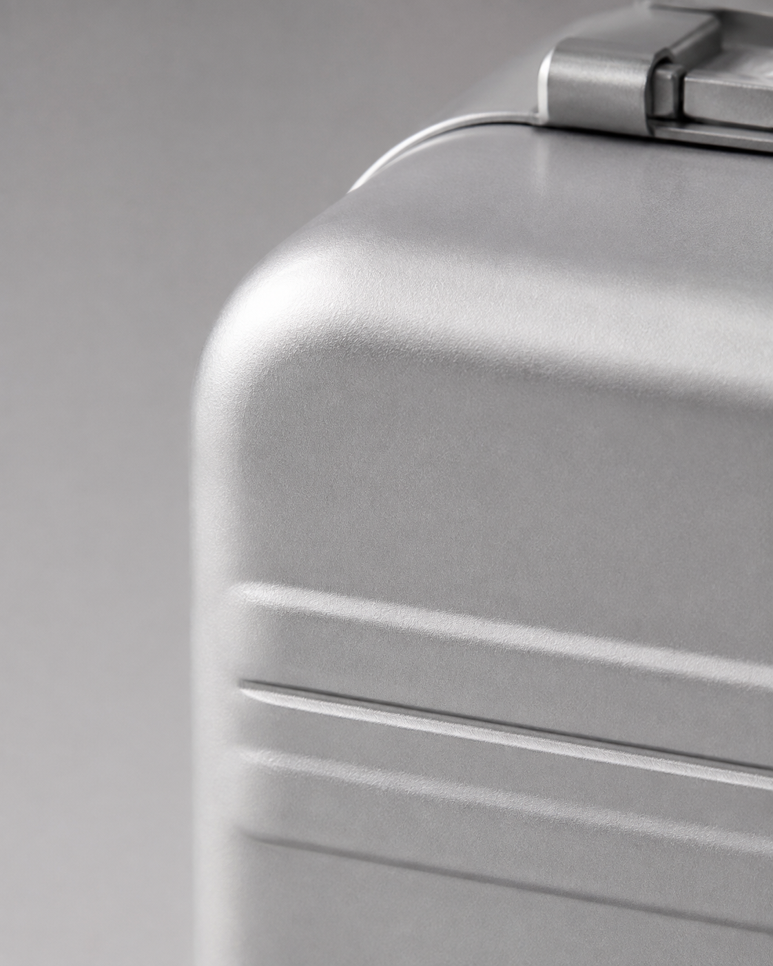 Close view of a rounded corner and edge seam on a silver AC47 Case shell.